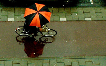 Iry od používání kol mimo jiné odrazuje počasí. Na snímku amsterodamský cyklista v dešti.