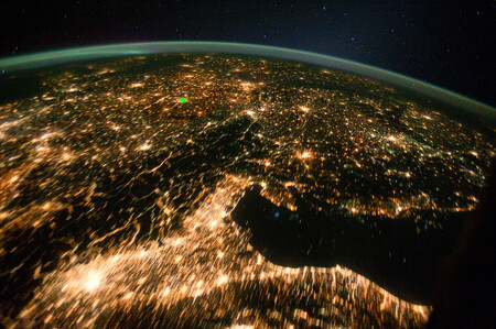 Satelitní snímek střední a jižní Evropy v noci ukazuje, jak města září do prostoru. Praha je označena malou zelenou tečkou. Snímek je z února 2011.
