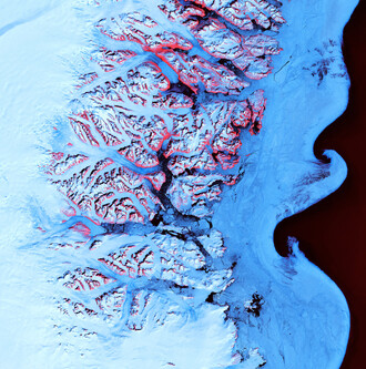 Tající led v letním období odhaluje skryté skály na jihovýchodním pobřeží Grónska (na obrázku červeně)