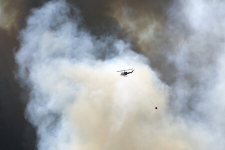 S ohněm ve městě a okolí bojuje téměř tisíc hasičů, které ze vzduchu podporují desítky helikoptér a letadel s vodou.