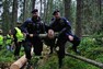 Policisté vynáší z lesa aktivistu, který byl při blokádě na Šumavě v červenci 2011 řetězem přivázán ke stromu. Další fotografie na webové stránce autora.