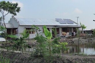 &quot;V Bangladéši se Světová banka rozhodla podpořit elektrifikaci venkovských oblastí, takže tam existuje spousta malých i velkých společností, které instalaci fotovoltaiky zajišťují. Jen jsme připravili zadávací dokumentaci, podmínky použití a kompetence ohledně panelů, regulátorů apod., vyhlásili jsme výběrové řízení, vybrali společnost a zkontrolovali, jak to udělala.&quot; Na ilustračním snímku domek na bangladéšském venkově s instalovanými panely