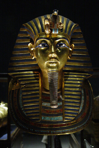 &quot;Největším pokladem Egyptského musea je nepochybně Tutanchamonova hrobová výbava – fascinující nejsou zdaleka jen známé a kapitální nálezy jako dvojitý sarkofág s množstvím masivního zlata a drahokamů. Mnohem zajímavější je množství další výbavy – pět válečných vozů a pět postelí, tři podivná ceremoniální lehátka ve tvaru zvířat, veliké množství šípů a luků, bumerangů, ceremoniálních holí různých tvarů atd. Na snímku Tutanchamonova maska.