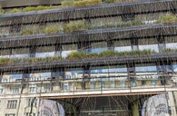 Pohled na Palác DRN a jeho vnější fasádu s truhlíky s okrasnými travinami z Národní ulice 