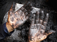 Ruce ženy vyrábějící brikety z biomasy