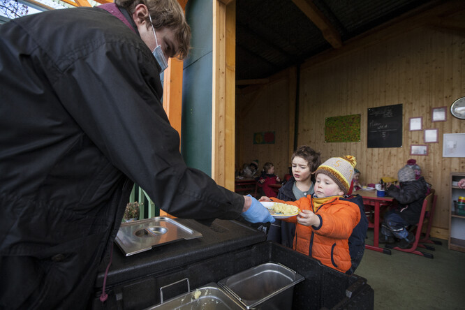 Výdej jídla v lesní školce.