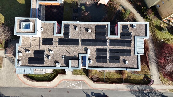 Nová fotovoltaika na střeše bytového domu.