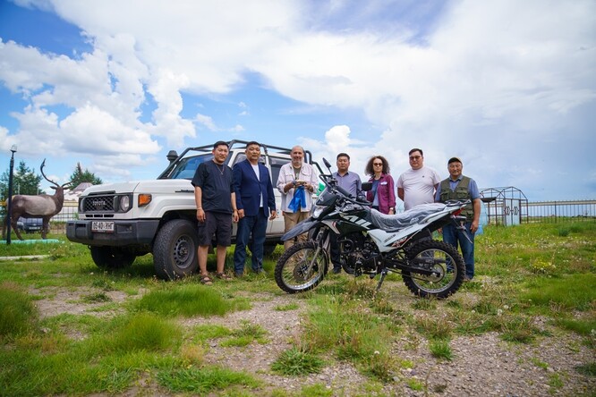 Slavnostní předávání terénního auta a motocyklu. Zleva: pracovník organizace Pomáháme jim přežít – Mongolsko S. Dalajceren, ředitel národního parku Nömrög D. Naranbátar, Miroslav Bobek, guvernér okresu Chalchgol E. Bjambadžargal, mongolistka Veronika Kapišovská, předseda okresního zastupitelstva P. Itgeltögs, ředitel Pomáháme jim přežít – Mongolsko O. Ganbátar.