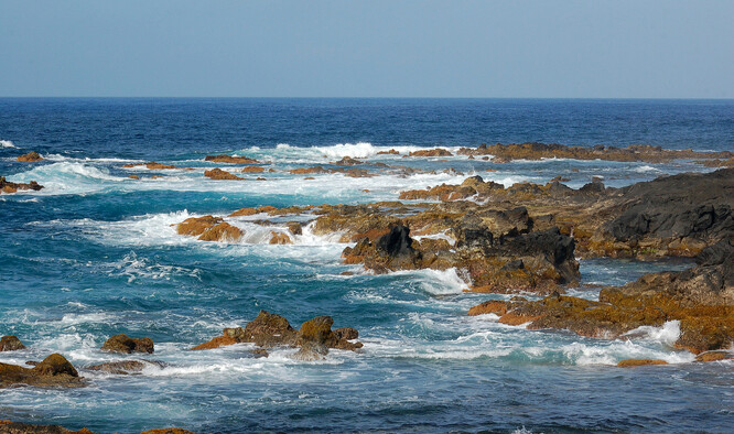 "Vlny většinou zběsile narážejí na rozeklané pobřeží s lávovými balvany a možnost koupání mimo zcela chráněné zátoky či přirozené bazény se limitně blíží nule a hraničí se sebevraždou." Na snímku Azorské pobřeží.