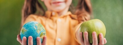 Holčička s jablkem a malým glóbem Foto: Depositphotos