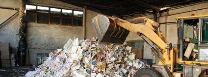 Bagr nakládá papírový odpad v hale Foto. Depositphotos