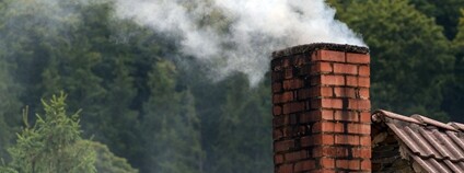 Kouřící komín na domě Foto: Depositphotos