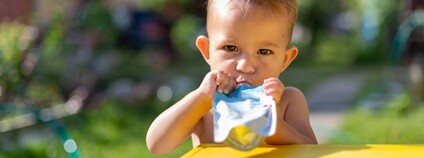 Dítě pochutnávající si na svačině z plastové kapsičky Foto: Depositphotos