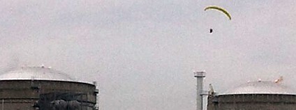 Aktivista Greenpeace hází dvě dýmovnice na budovy jaderné elektrárny Bugey. Foto: Greenpeace