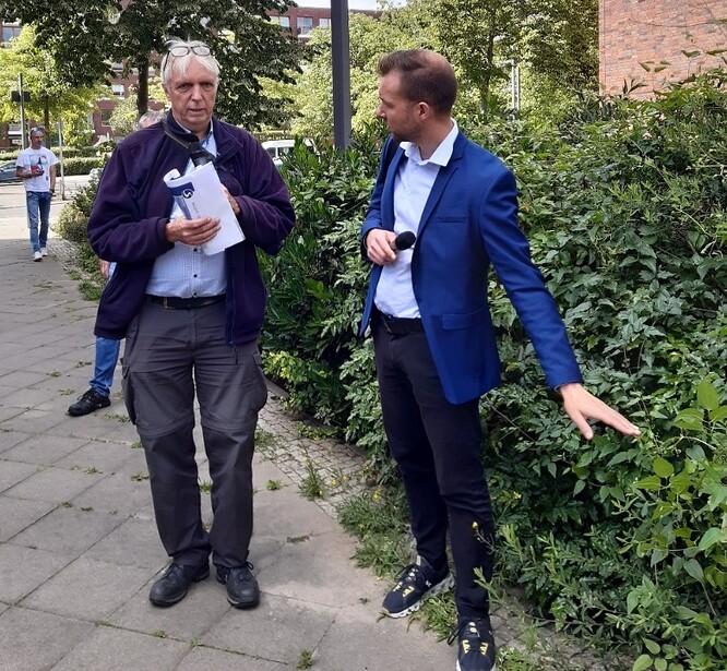 Obr. 8. Harald Sommer (vlevo) a tlumočník ukazují část průlehu, která je osázena keři.