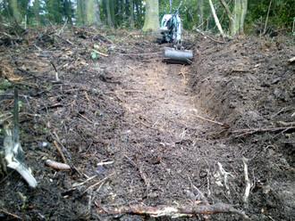 Hloubení zasakovací strouhy v lese.