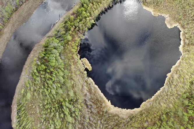 Jezero Suzdalevo, jehož sedimenty posloužily k rekonstrukci změn ve vodním prostředí následujících po Tunguské události. Lokalita se nachází v odlehlé oblasti tunguské státní rezervace, kde díky explozi v r. 1908 došlo k rozsáhlé destrukci místní tajgy. Vlevo nahoře jsou patrné lodě kotvící u břehu řeky Chamba, která pro proběhlou expedici představovala spojnici mezi jezerem a nejbližší civilizací.