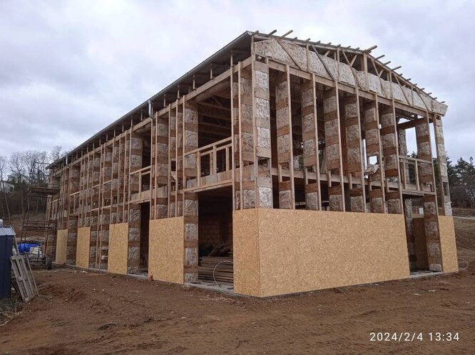 Konstrukce obvodového pláště rodinného domu z dřevěných sbíjených a lepených příhradových vazníků již při výrobě vyplněných minerální vatou.