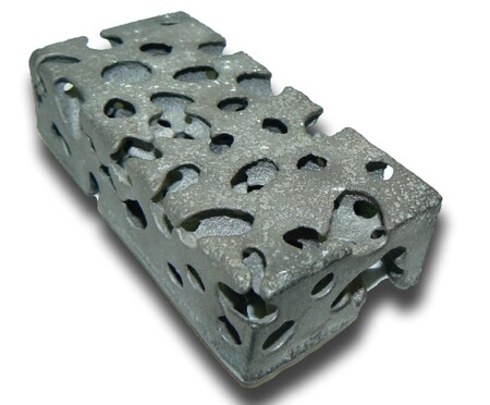 Zpěněný kov v nepravidelné struktuře.