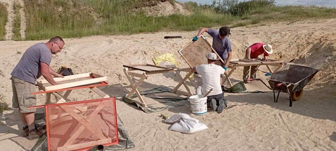 Hledání zkamenělin přes síta.