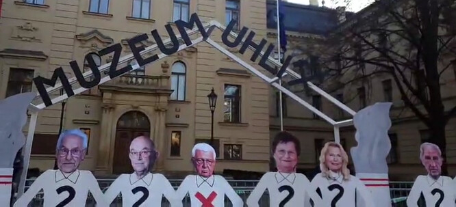 Aktivisté na místě vystavěli konstrukci, která znázorňuje vstup do muzea uhlí. K tomu dali makety se zestárlými tvářemi ministrů a ministryň, u nichž je znázorněno, kdo jaký scénář podporuje.