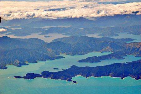 Nový Zéland jako celek je zvláštním způsobem přízračný, bizarní pevnina ztracená v oceánu – je zcela jiný než Austrálie, vulkanický a geotermálně činný s rozeklaným romantickým pobřežím, vhodným tak k točení scén z tolkienovských jinozemí, plný gejzírů, horkých pramenů a romantických vrcholků hor. Na ilustračním snímku Záliv princezny Charlotty