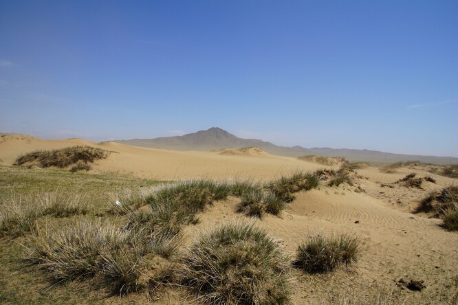 Písek na duně vířený a odnášený silným větrem.