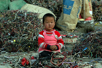 Čína už nechce být smetištěm zbytku světa. Na snímku čínské děvčátko mezi hromadami odpadních kabelů.