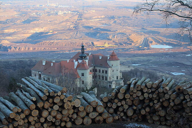 Ikonický pohled na měsíční krajinu uhelného velkolomu ČSA přes zámek Jezeří teď doplňují vyskládané klády z pokácených stromů.