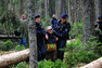 Policisté vynáší z lesa aktivistku.