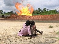 Děti z nigerijské vesnice Rumuekpe sledují hořící zemní plyn.