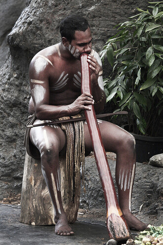 Prodejny suvenýrů praskají pod náporem nápodob aboriginských tradičních maleb a artefaktů, trubka didžeridu je naprosto erbovním předmětem kontinentu. Na ilustračním snímku Austrálec s didžeridu