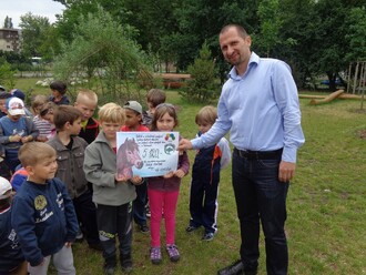Děti z Mateřské školy Kostička předávají symbolický šek s darem pro divoké koně v Milovicích