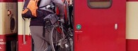 Cyklista nakládající kolo do vlaku