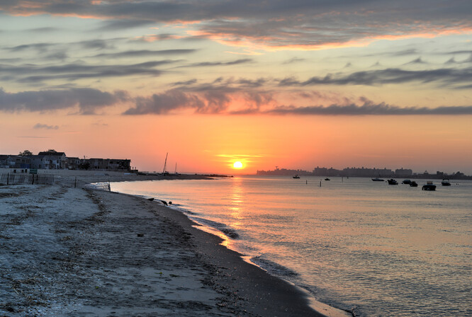 Západ slunce nad Rockaways Beach, Queens, New York.