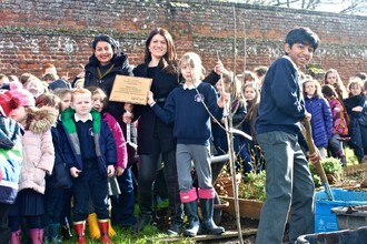 Britské děti při 25. výročí založení Roots & Shoots sází jabloň.