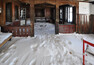 Východní veranda v lednu 2011. Sníh zakrývá vyboulenou podlahu, na níž se válejí matrace přitažené z pokojů, plechovky od piva a láhve od alkoholu