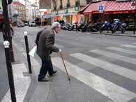 Starý muž přechází ulici