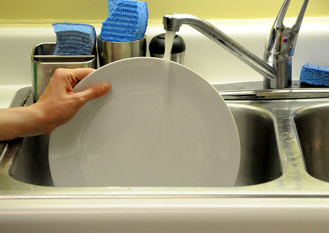 Mytí nádobí pod tekoucí vodou je šetrné jen v případě, že je potřeba umýt pár kousků nádobí, pro které se nevyplatí napouštět dřez.