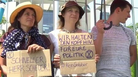 Zhruba 30 aktivistů bojujících proti změnám klimatu se včera připoutalo zamčenými řetězy k plotu před budovou německého kancléřství v Berlíně.